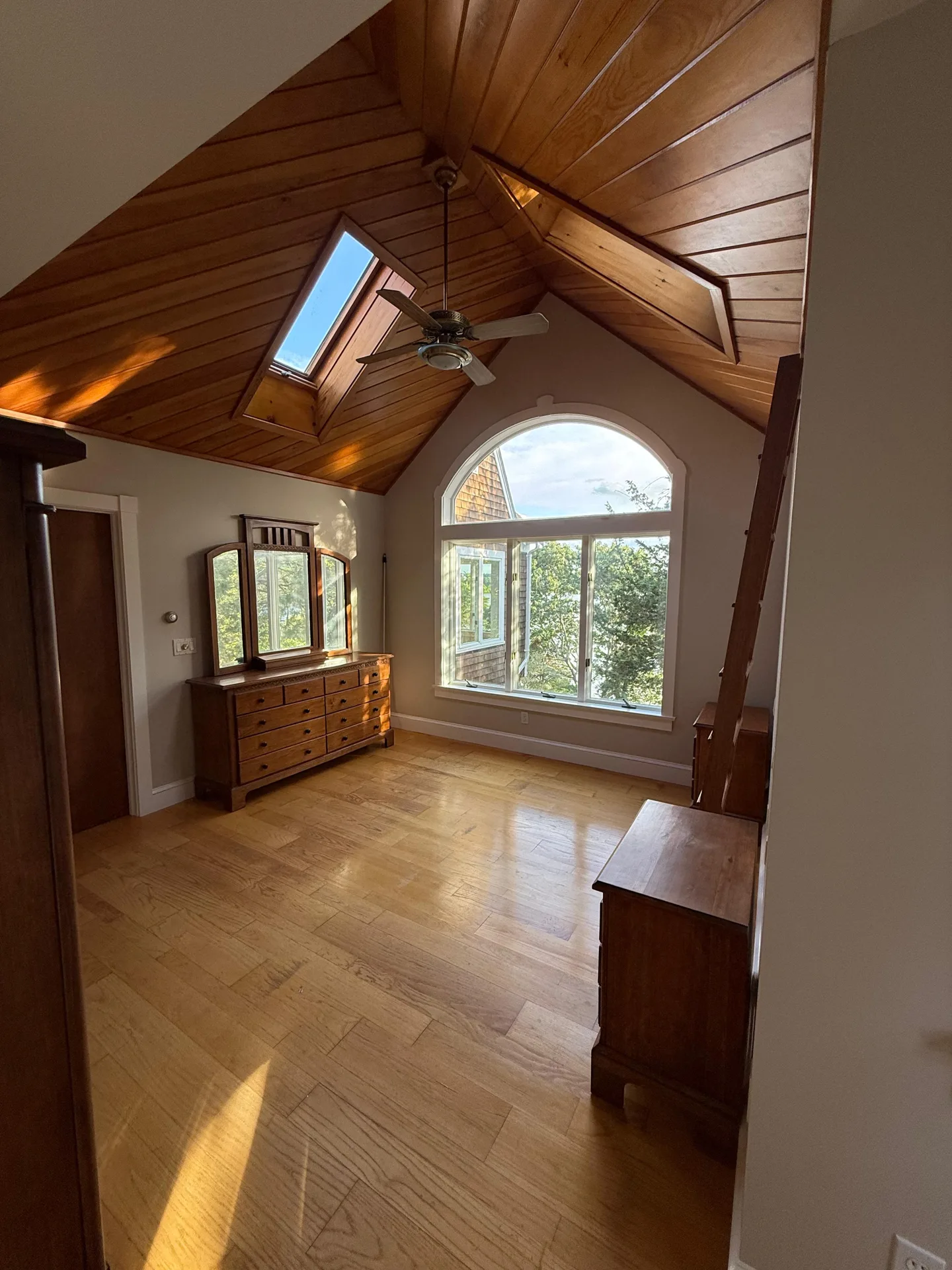Primary bedroom with arched window and clean neutral wall finish