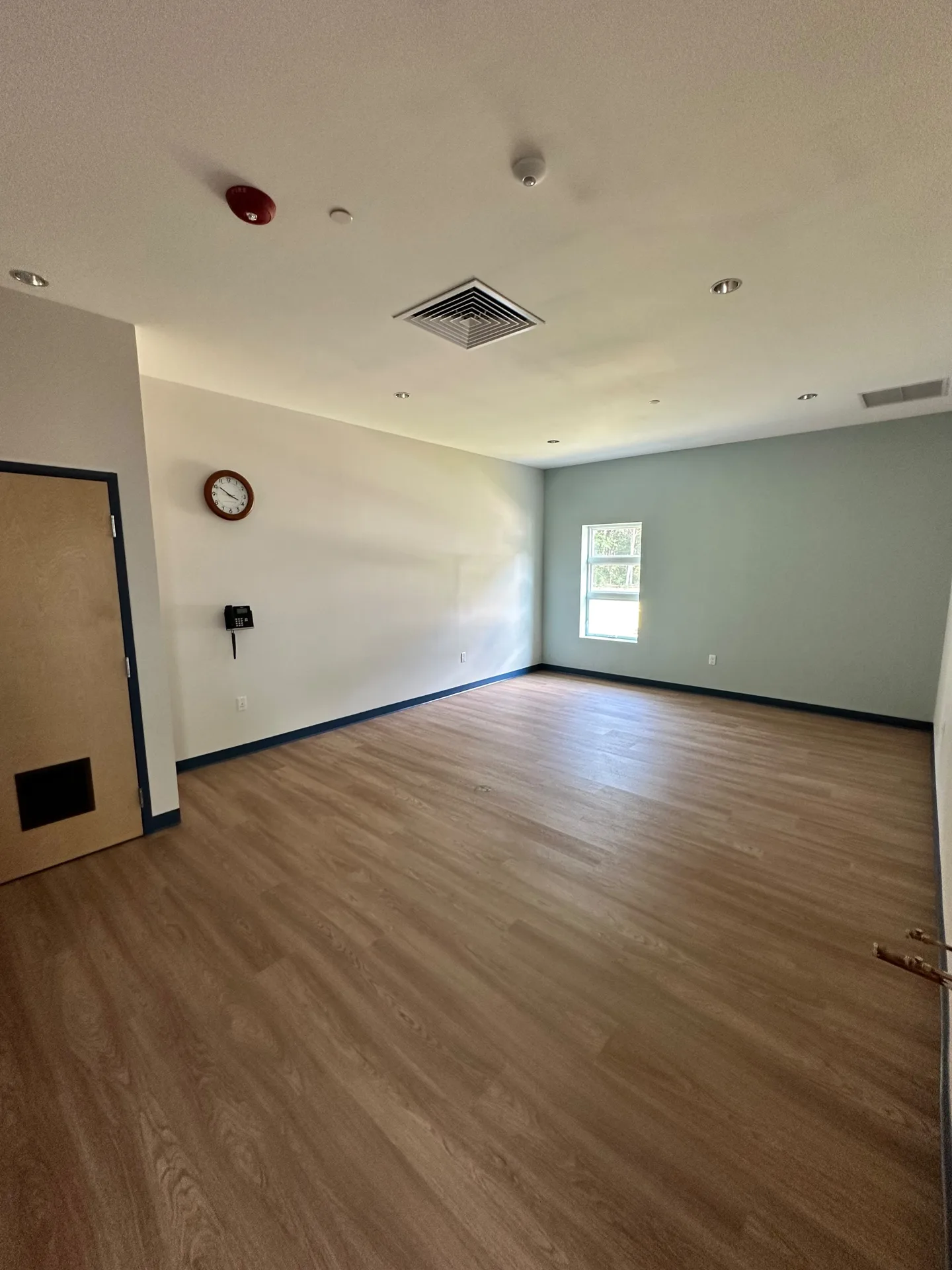 Classroom with clean neutral walls and dark baseboards