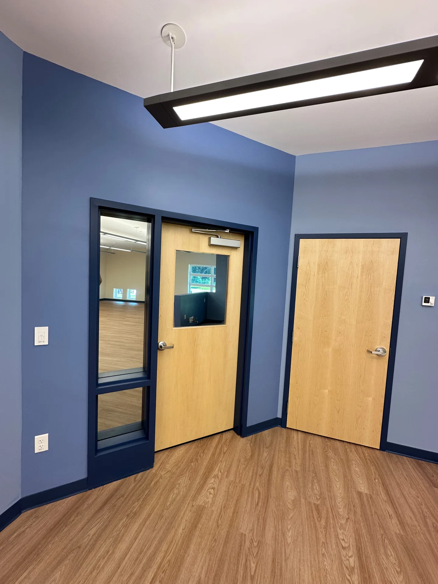 School hallway with navy blue accent walls and painted door frames