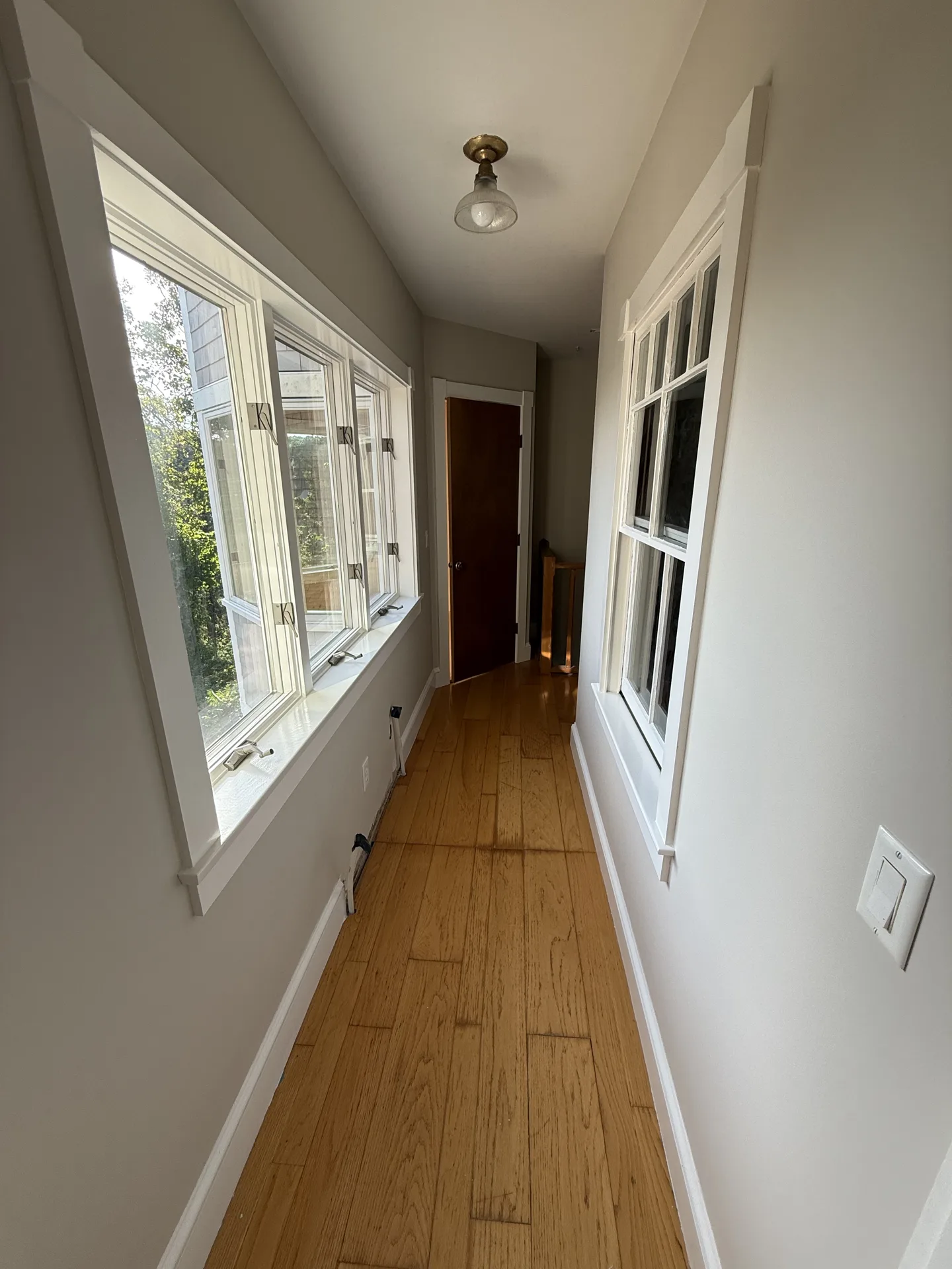Window lined hallway with freshly painted walls and trim