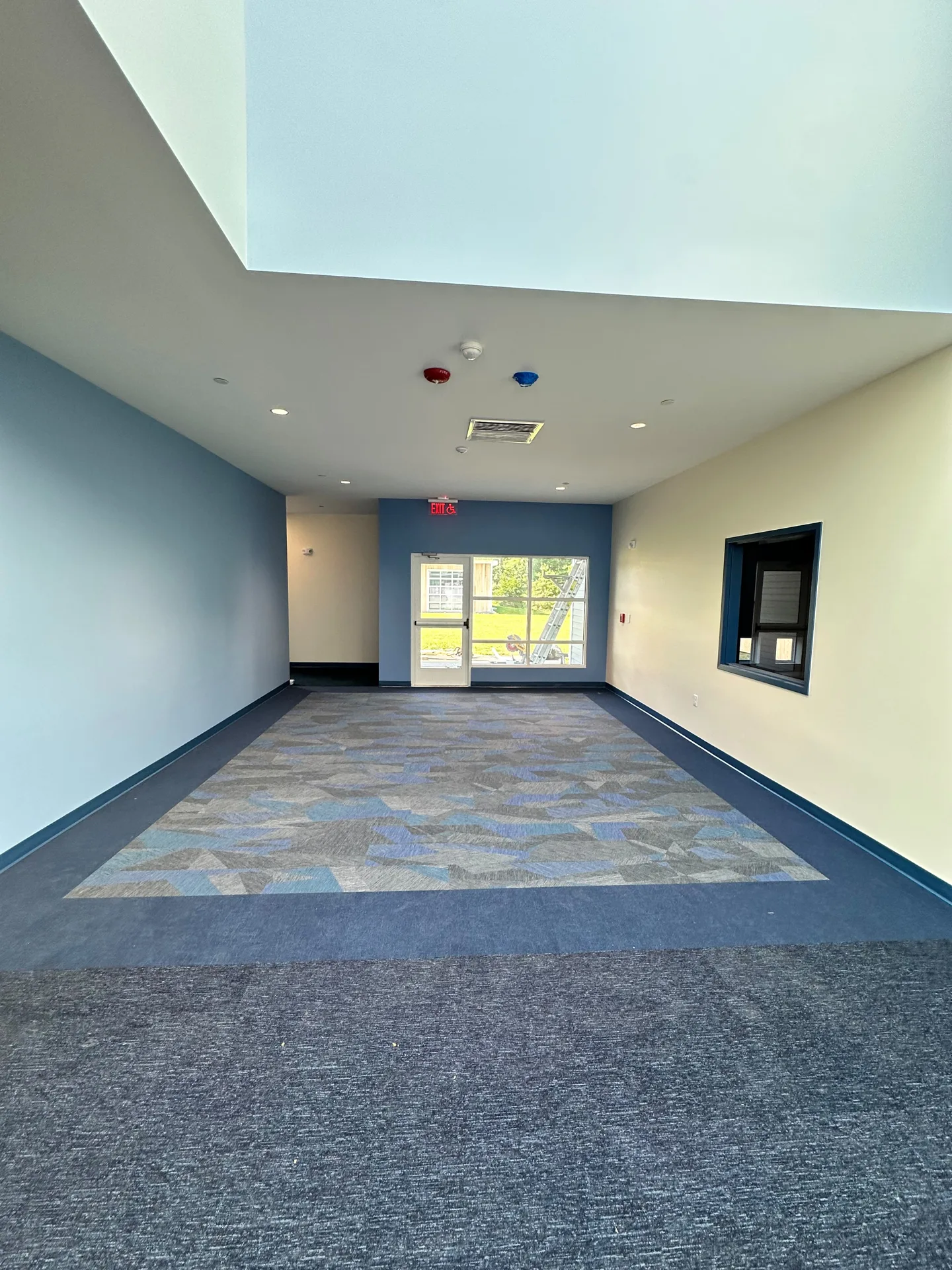 School entry area with skylight, light blue walls and navy window trim