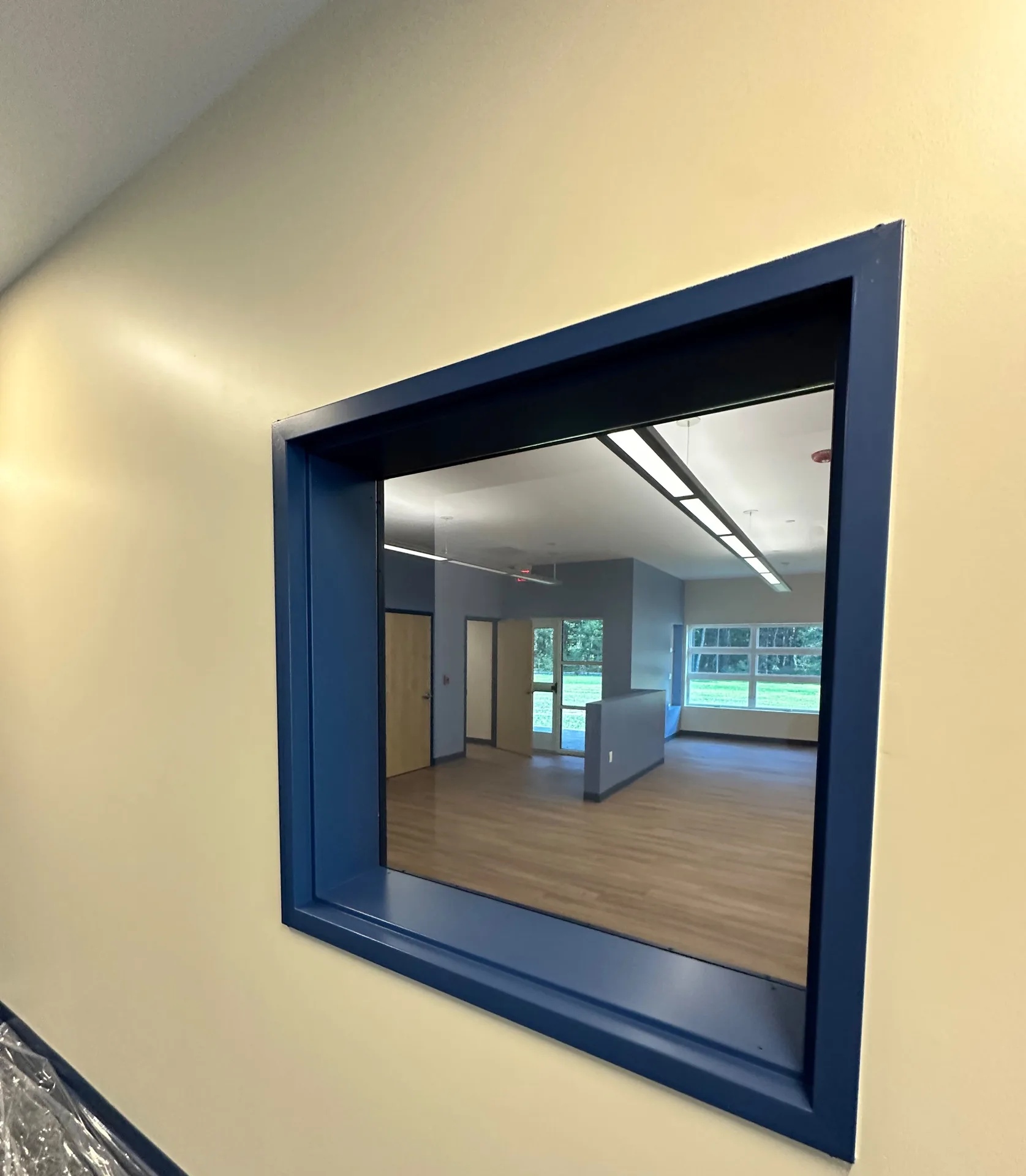 Interior window with navy painted frame between classrooms