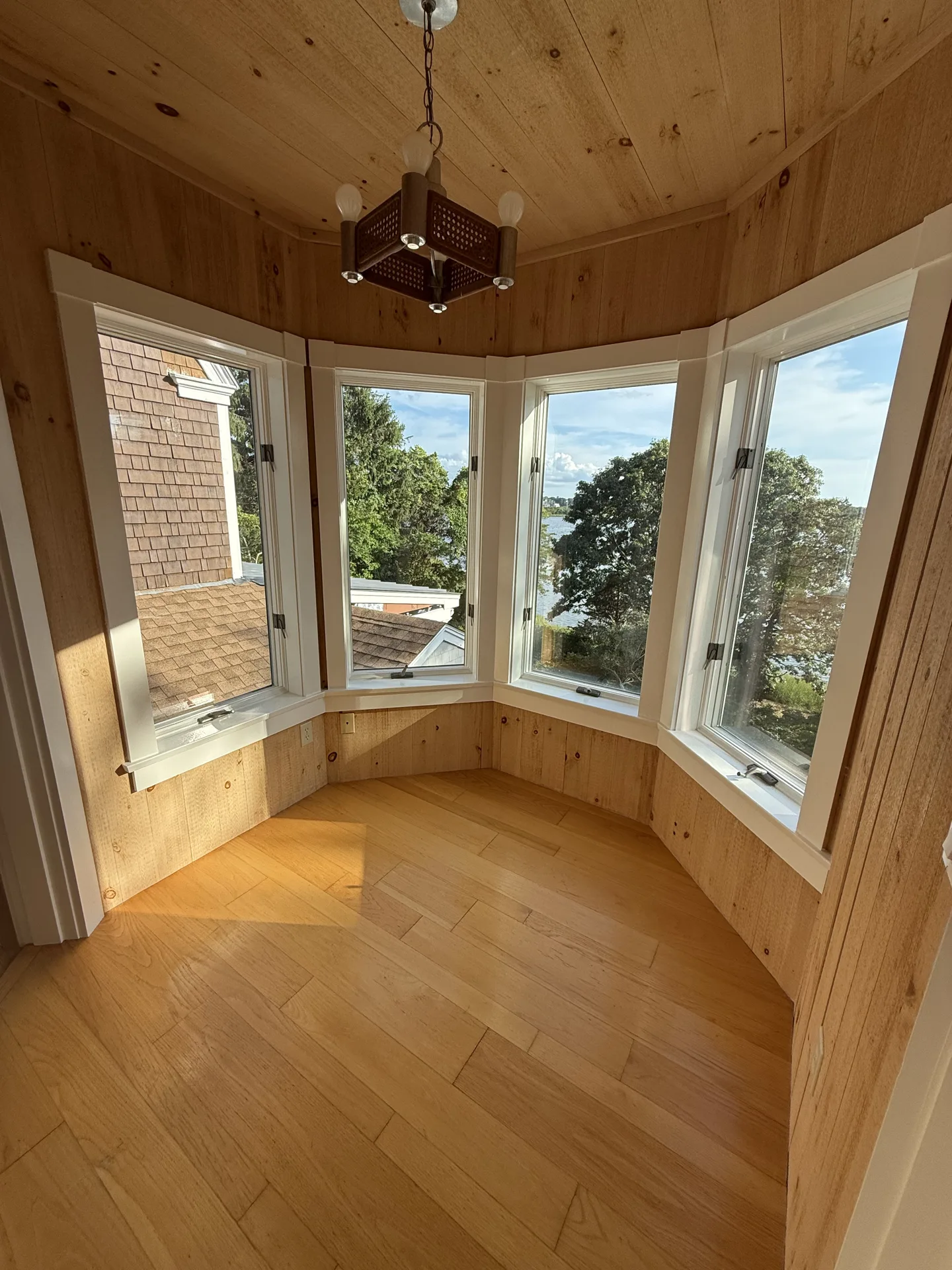 Bay window sitting room with natural wood ceiling and painted trim